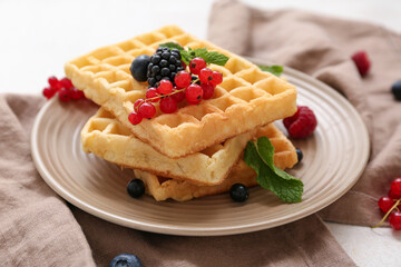 Plate of sweet Belgian waffles with different fresh berries and mint on white background, closeup