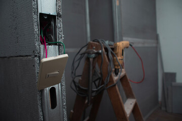 Escena de cuarto en remodelaci&oacute;n, con apagador en primer plano.