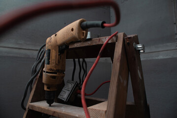 Herramienta de construcci&oacute;n, taladro sobre escalera de madera.