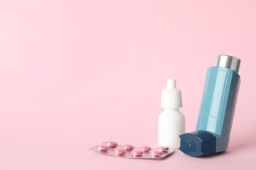Different asthma medications on pink background, closeup. Space for text
