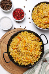Pilaf and spices on white background, top view