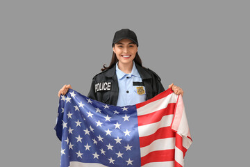 Female police officer with flag of USA on grey background