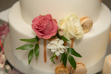 White wedding cake decorated with pink and white roses