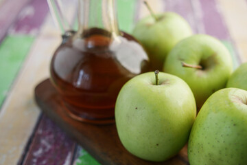 apple vinegar in glass bottle with fresh green apple on table 