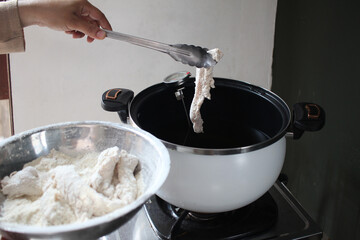 Process of deep frying breaded crispy chicken in hot oil