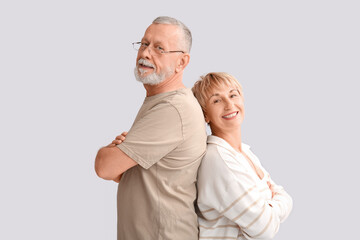 Mature couple smiling on light background