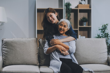 Adult daughter old mom hugging sit on couch enjoy pleasant positive talk, remembering funny occasion from life spend weekend together, caring about older generation relatives express attention concept