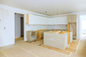 Installing new custom kitchen cabinet during construction of home improvement project