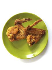 two pieces of fried chicken on the table in a green plate, daily food