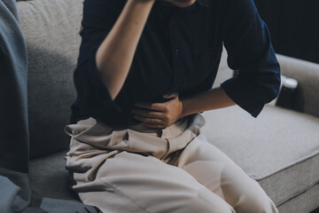 A woman with a cold with pills is treated at home chooses which drugs to take and self-medicates, checks the expiration date while sitting on the couch at home