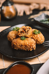 a plate of food containing several pieces of croquettes