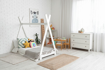 Interior of children's room with bed, table and commode
