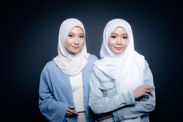 Portrait of a beautiful Malaysian and Indonesian Muslim young women wearing modern and casual wear with hijab on isolated studio background. Modern hijab fashion and beauty concept