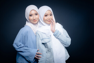 Portrait of a beautiful Malaysian and Indonesian Muslim young women wearing modern and casual wear with hijab on isolated studio background. Modern hijab fashion and beauty concept