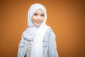 Portrait of a beautiful Malaysian and Indonesian Muslim young women wearing modern and casual wear with hijab on isolated studio background. Modern hijab fashion and beauty concept