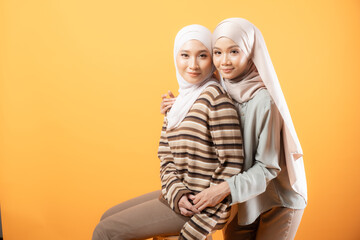 Two beautiful Malaysian and Indonesian Muslim young women wearing modern and casual wear with hijab on isolated studio background. Modern hijab fashion and beauty concept