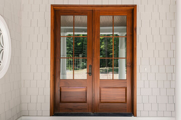 Luxury Wooden Double Doors With Glass Panes Leading To A Porch Area