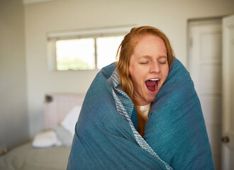 Woman, blanket and tired in morning with yawn for burnout, warm and sleeping problem in home. Female person, wake up and open mouth in bedroom for fatigue with duvet, insomnia and relax in Ireland