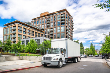 Middle duty day cab white compact bonnet rig semi truck with box trailer unloading delivered to...