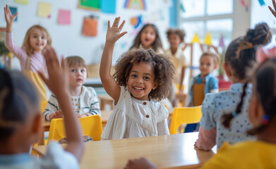 Children raising hands in a classroom with excitement.
