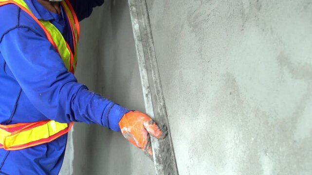 Close up hand worker uses tools to smooth plaster on a wall Home construction and home decoration archive in architecture