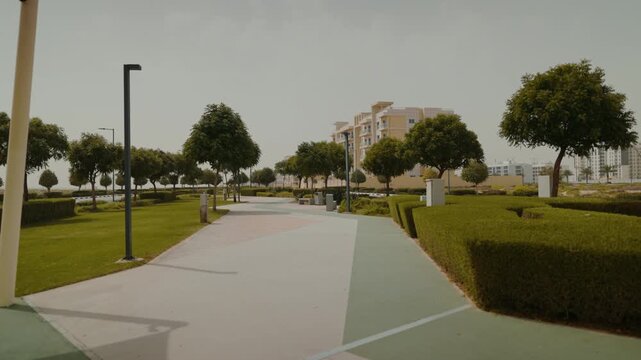 Discover Dubai South's residential district, featuring a vibrant playground, grand market, and lush park with greenery and trees, located next to Al Maktoum Airport.