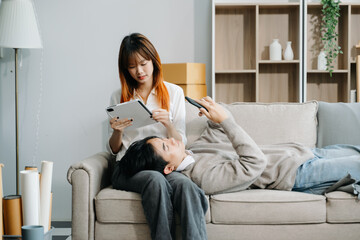 Happy asian young attractive couple man and woman with big boxes moving into a new house, new...