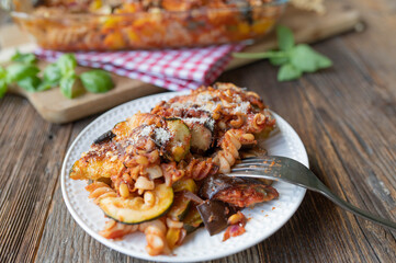 Plate with delicious vegetarian pasta casserole. Cooked with ratatouille vegetables such as...