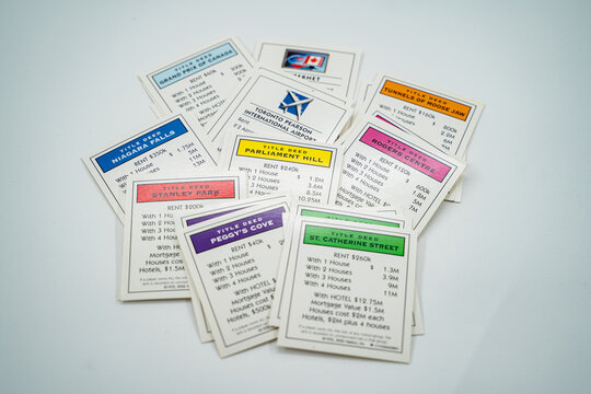The deed cards on a Canada Monopoly board game on a white background. Toronto, Canada - July 23, 2024.