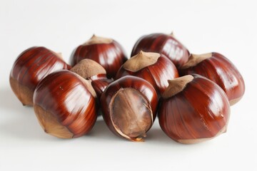 Obraz premium Shiny brown chestnuts artistically arranged on white background