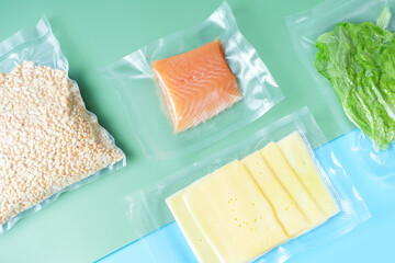 Different types of food packed in vacuum bags on blue and green background top view.