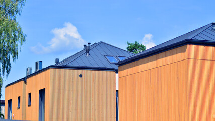 Residential homes with modern wood facade. Terraced family homes in newly developed housing estate. The real estate market in the suburbs.