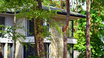 Upscale house in wooded area. Fragment of a single-family house facade. 