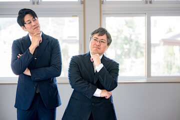 悩む二人のビジネス男性