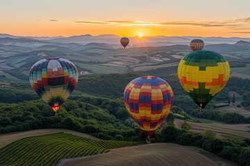 Fototapeta premium Colorful hot air balloons soar above sunset mountains and meadows in a picturesque evening scene