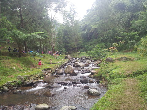 a calm rocky lake in a tourist spot, curug capolaga, indonesia