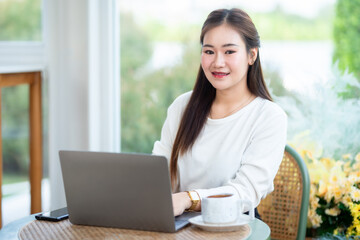 asian freelance people business female talking making using casual working with laptop computer for browsing internet, chatting and blogging and smartphone,notebook in coffee shop.