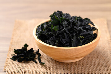 Dried Wakame seaweed or sea mustard in wooden bowl