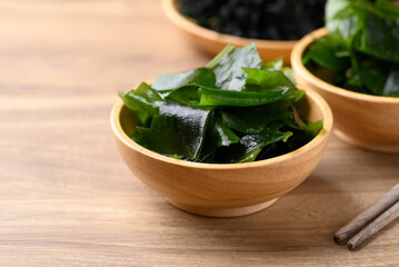 Fresh Wakame seaweed or sea mustard in wooden bowl