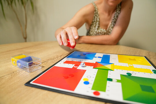 Mother moving game piece during board game with son at table