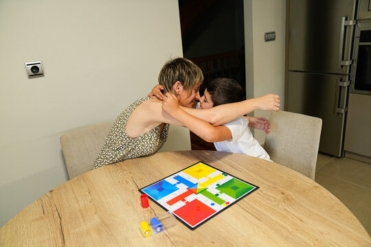 Mother and son sharing a hug after playing a board game