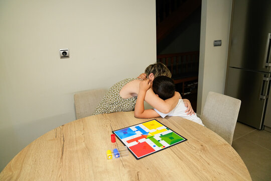 Mother and son hugging warmly after playing a board game