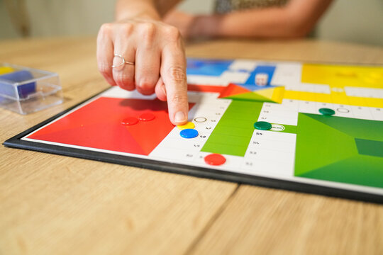 Mother pointing at board game pieces while playing with her child