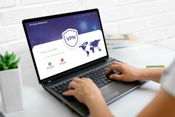 Using a VPN on a laptop. Web page concept with VPN connection and world map, emphasizing global...