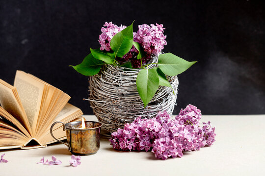 Candle holder, old book and lilac flower.