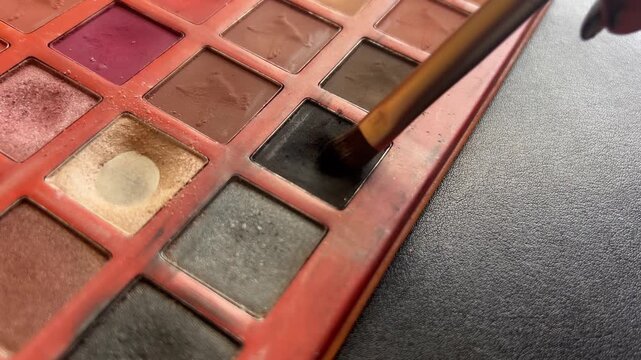 Small paint brush using black color. Makeup palette. Copy space.