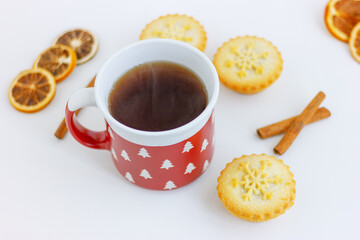 red cup, dried lemon, cinamon and mini cake with snowflake on table