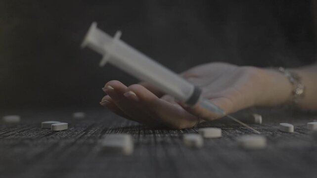 Hand with syringe falls on the table