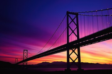 Fototapeta premium Silhouette of a Bridge Against a Vivid Sunset Sky