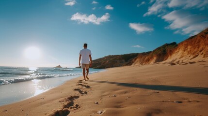 Lonely man walking on the beach leaving footprints